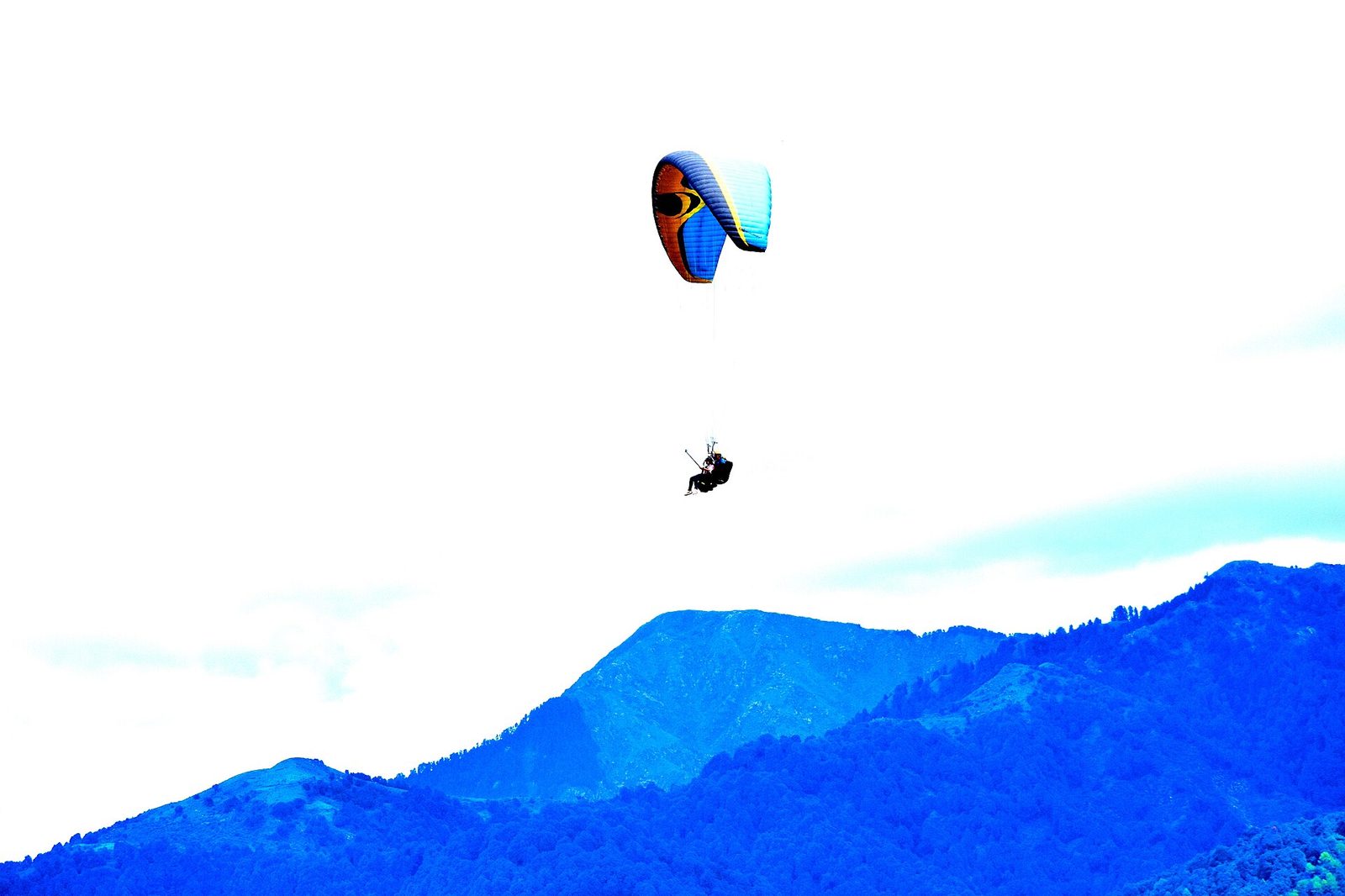 Paraglider flying over the Bir Billing ridge in Himachal Pradesh